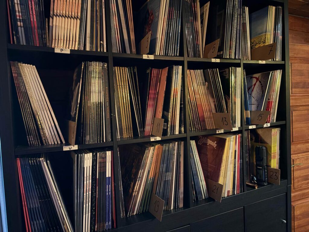 Czarny regał z płytami winylowymi ułożonymi alfabetycznie w magazynie music-space
